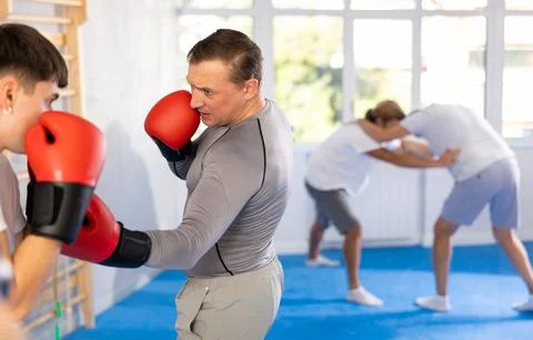 Two men in boxing training perform sparring and one man blocked blow Stock Photos