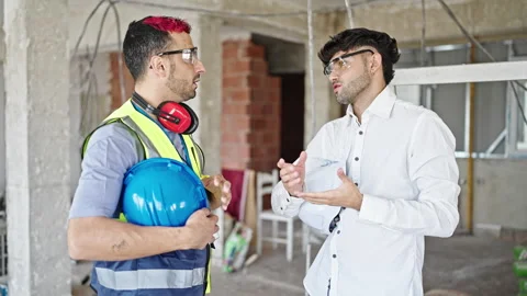 Two men builder and architect smiling confident speaking at construction site Video stock 245041335