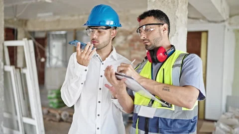 Two men builders and architect writing on document sending voice message by.. Stock Footage 242338378