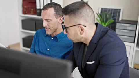 Two men business workers using computer reading document at office Stock Footage 243487031
