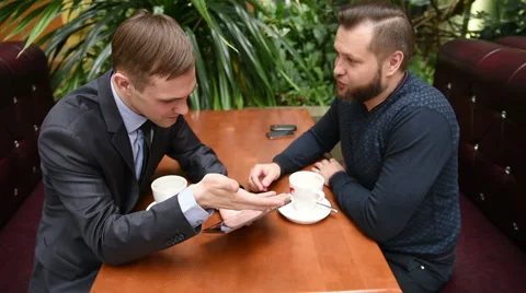 Two men at a cafe using a Tablet PC. upset Stock Footage 62181576