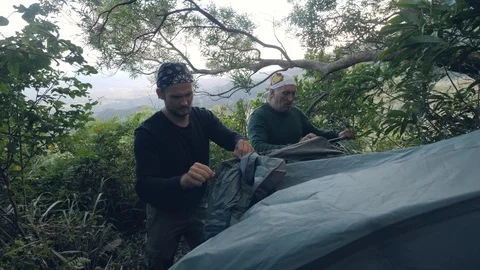 Two men campers setting up tent in forest camping to rest in unity with nature. Stock Footage 118412962