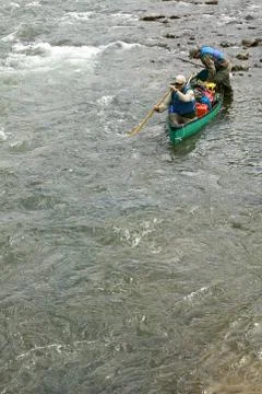 Two men in a canoe navigating wild river rapids Foto stock
