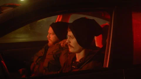 Two men in a car lowering ski masks over their faces Stock Footage 275177150