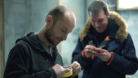 Two men in the car painting studio discuss the details of the work Stock Footage 73910282