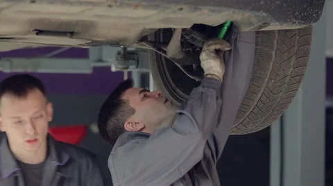 Two Men in Car Service Checking Car Bottom Stock Footage 62166858