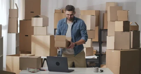 Two men carry cardboard boxes with goods indoors Stock Footage 149469839