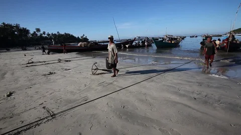 Two men carrying a basket of fish on the beach, Ngapali, Myanmar Stock Footage 123756013