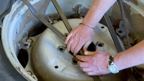 Two Men Changing the Wheel of a Tractor with Tools Stock Footage 274070897