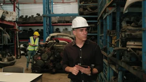 Two men checking engine parts in a warehouse. Video stock 151969331