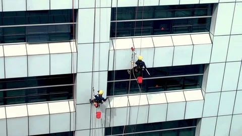 Two men cleaning high rise building windows with harness and safety equipments. Stock Footage 123047562