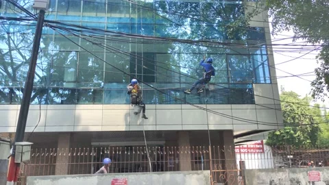 Two men cleaning window glasses at commercial building Video stock 163858916
