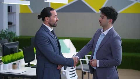 Two men, colleagues, directors in suits in the office are shaking hands Stock Footage 233716952
