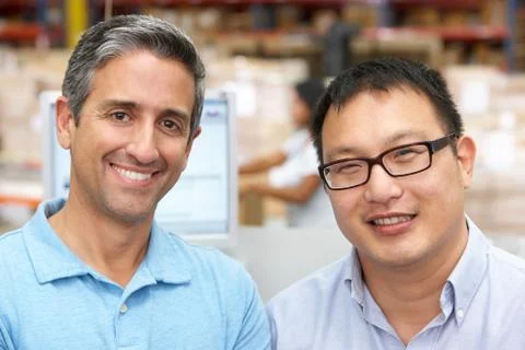 Two men at computer terminal in distribution warehouse 写真素材