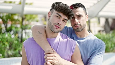 Two men couple hugging each other with relaxed expression at park Stock Footage 245555691