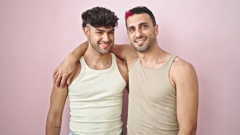 Two men couple smiling confident hugging each other over isolated pink back.. Stock Footage 246131022