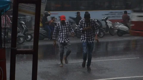 Two-men-cross-street-during-heavy-rain Stock Footage 115183840