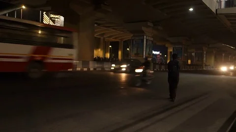 Two men crossing a busy road with heavy traffic at night in Hyderabad,India Stock Footage 83786173