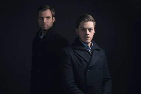 Two men in dark blue winter coat. Stock Photos