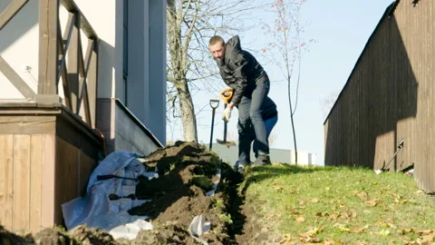 Two men digging a trench using shovels to make automatic watering of plants. 4K Stock Footage 107714767