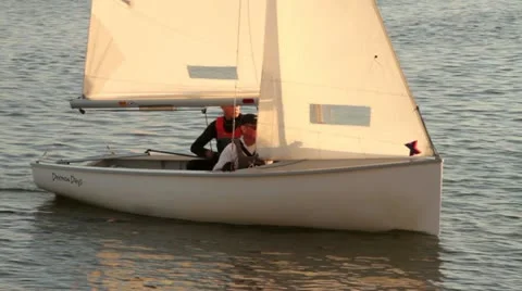 Two men in a dinghy sail in warm evening light Stock-Footage 11799771