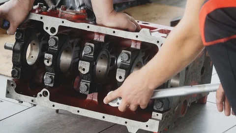 Two men disassemble the car engine at the factory. Top view Stock Footage 94899037