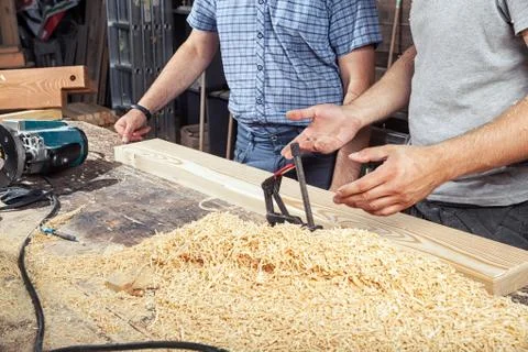 Two men discuss how to process a wooden board Stock Photos