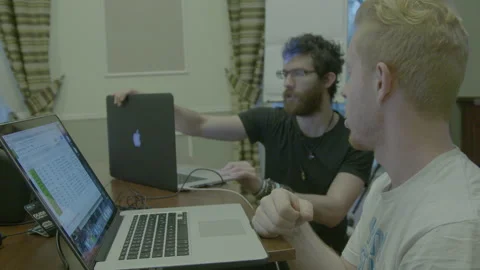 Two Men Discussing Project Details on Laptops Stock Footage 341863143