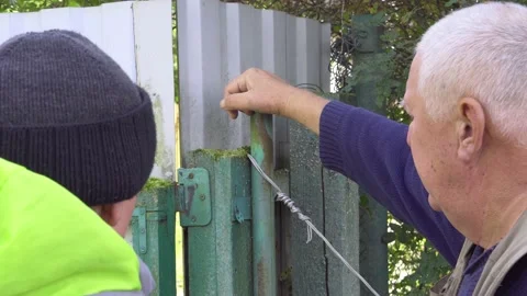 Two men discussing the scope of work on the repair of the gate. Close up Stock Footage 161606248