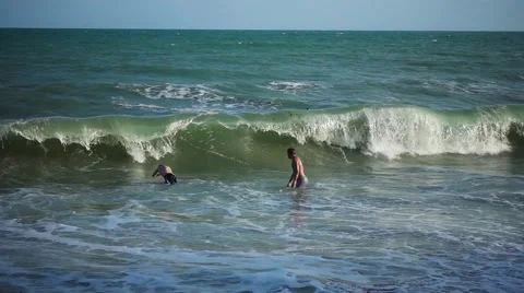 Two Men Dive into Coming Wave. Slow Motion Stock Footage 58696233