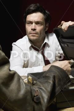 Two men doing business over a suitcase full of money Stock-Fotos