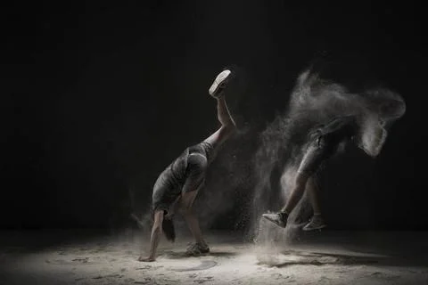 Two men doing handstand in white dust cloud view Two young men in sportswe... Stock Photos