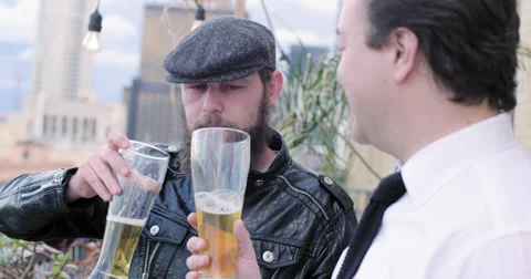 Two men drinking lager from tall glasses at party Downtown LA at sunset 4K Stock Footage 63498073