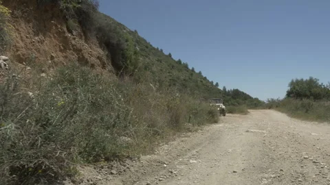 Two men driving a Jeep in the sand passing fast in front of the camera Stock Footage 200859470
