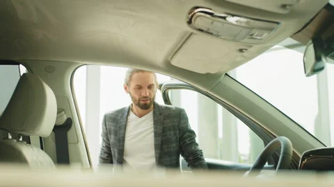 Two men elderly father and adult son in a showroom choose a new car. A elderly Stock Footage 240555853