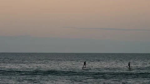 Two men on Electric surfboards at sunset 4K Video stock 155420111