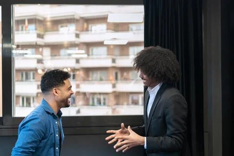 Two men engaging in a lively conversation at work. Foto stock