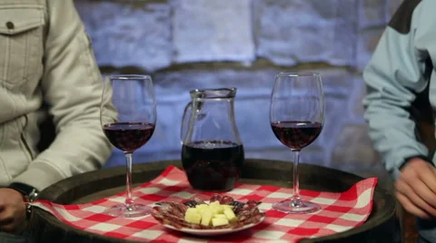 Two men enjoying home made red wine and snack in a cellar. Stock Footage 45169708