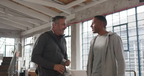 Two men entering loft, older man starting chat, gesturing with bottle and Stock Footage 337255194