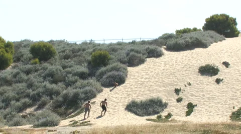 Two Men Excercise by Running Up Sand Dune Hill Stock Footage 4280088