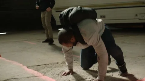 Two men fight, one man get's punched in front of an abandoned camper trailer in Stock Footage 199459352