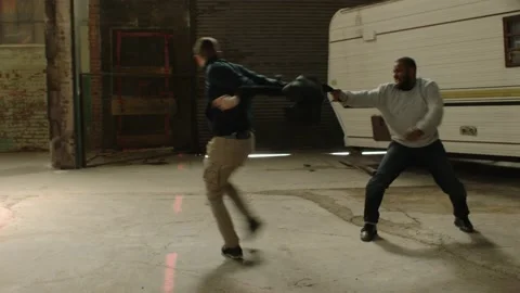 Two men fight over possession of knapsack using martial art techniques, in front Stock Footage 199460179