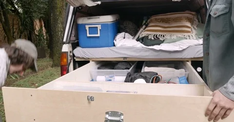 Two men finish packing their pickup truck for their journey adventure together Stock Footage 80810585