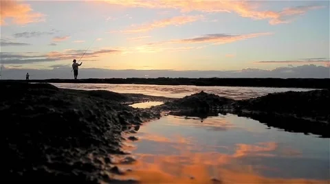 Two Men Fishing on Beach, Reflection of Sunrise Stock Footage 46219425