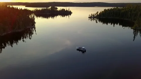 Two men fishing from a boat at sunset on, Stock Video