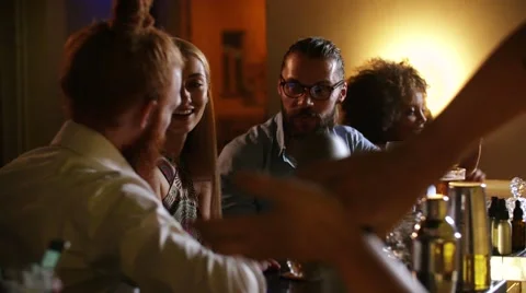 Two men flirts with a very beautiful blonde woman in a luxury bar. They drinks a Stock Footage 67277786