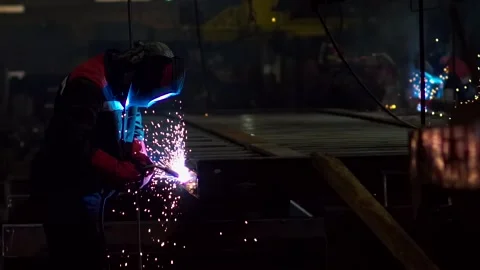 Two men in the form of welders welding machines in the factory weld metal Stock Footage 154364052