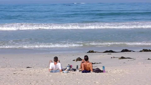 Two men friends on the beach looking out at the ocean Video stock 333717644