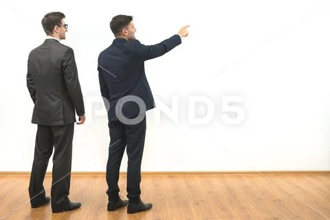 The two men gesture on the white wall background Stock Photos