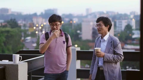 Two men having a coffee break at the terrace of kLab in Kigali, Rwanda Stock-Footage 82341244